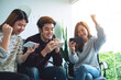 © Farknot Architect - A group of young people having fun and celebrating while watching and playing games on mobile phone together