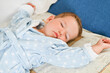 © Tatsiana - Adorable toddler baby slepping in bed with arms up.