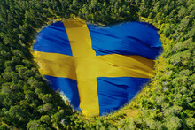 Heart-shaped Swedish Flag In Woodland Lake