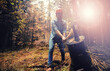 © alexkich - Male worker with an ax chopping a tree in the forest.