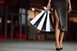 Shopping bags of women crazy shopaholic. Fashionable woman dressed in a black dress  with shopping bags. Purchases, black Friday, sale concept.