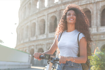 Woman riding e-scooter while visiting the Colosseum in Italy