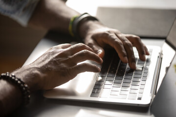 close up male hands typing on laptop keyboard, african american man working online, blogger preparin