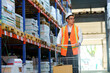 © Andrii  - Warehouse worker walks between the shelves with a trolley