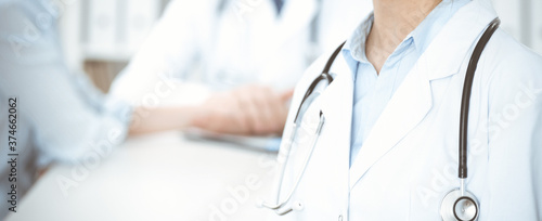 Fotomural Group of unknown doctors discussing problems to stop coronavirus pandemic while sitting at meeting in clinic, close-up
