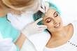 © rogerphoto - Professional beautician doing eyebrow tattoo at woman face. Permanent brow makeup in beauty salon, closeup. Cosmetology treatment