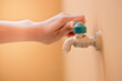A woman's hand is opening or closing the water from the tap for cleaning.