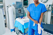 © DragonImages - Cropped image of medical nurse putting on rubber gloves and getting ready for surgery