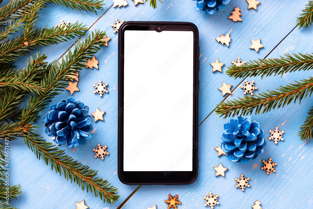 Phone on the table at Christmas with Christmas trees. - obrazy, fototapety, plakaty 