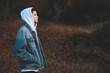 © morrowlight - Handsome teen boy 15-16 year old wearing denim jacket and white hoodie standing outdoors over nature autumn background. Teenagerhood.