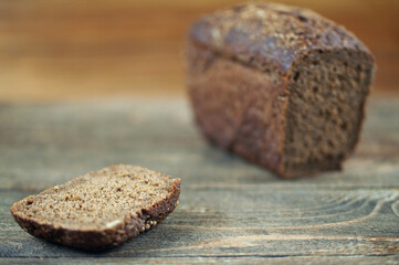 a loaf of black bread on a wooden background, the concept of rising bread prices