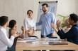© fizkes - Smiling male leader praising happy millennial arab colleague at group meeting. Smiling diverse coworkers applauding, supporting new worker or congratulating with personal professional achievement.