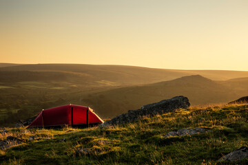stunning image of wild camping in english countryside during stunning summer sunrise with warm glow 