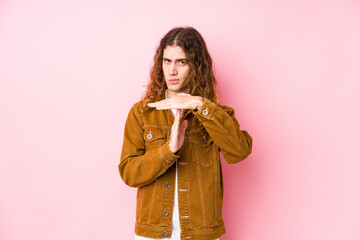 Wall Mural - Young long hair man posing isolated showing a timeout gesture.