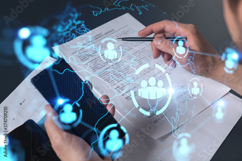 Cuadros en Lienzo Double exposure of man signing contract with phone and social network icon hologram