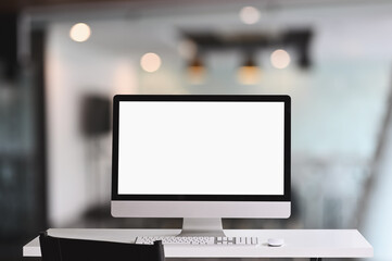 Workspace computer monitor with a white blank screen on white table.