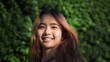 © Yanukit - happy face of asian girl on blur green bush street