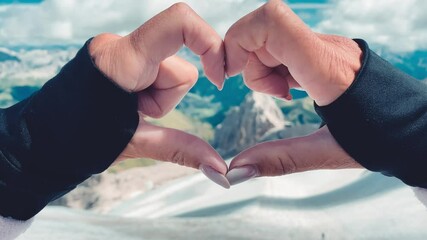 Canvas Print - Woman creating heart sign with her hands on a mountain scenario