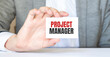 © Andrey - businessman holding a card with text PROJECT MANAGER