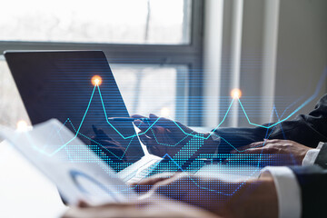 Two business people working together on corporate strategy. Try to analyze statistics. Financial forecast graph hologram. Double exposure.