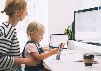 Wall Mural - Mother working from home with little child.