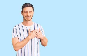 Handsome young man with bear wearing casual clothes smiling with hands on chest with closed eyes and grateful gesture on face. health concept.