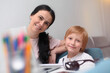 © as-artmedia - Coronavirus Outbreak. Lockdown and school closures. Mother helping her son studying online classes at home. COVID-19 pandemic forces children and teachers online learning