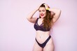 © Krakenimages.com - Young plus size redhead woman wearing sexy lingerie smiling happy Standing with smile on face and hands on hair over isolated pink background