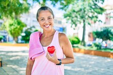 Middle Age Sportswoman Asking For Health Care Holding Heart At The Park