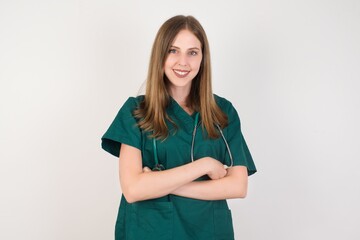 Female doctor wearing a green scrubs and stethoscope happy face smiling with crossed arms looking at the camera. Positive person.