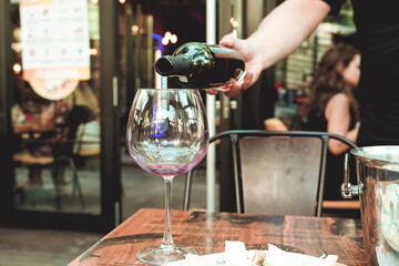 wine pouring red wine glass waiter hand in a cafe restaurant