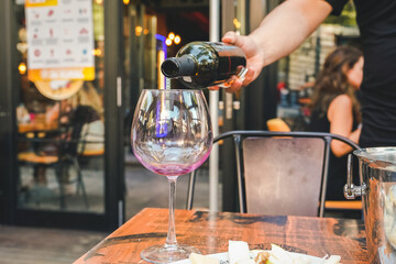 wine pouring red wine glass waiter hand in a cafe restaurant