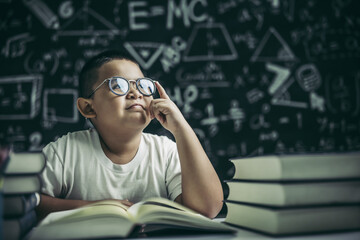 Wall Mural - Boys with glasses write books and think in the classroom