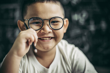 Wall Mural - A boy with glasses sitting in the classroom studying