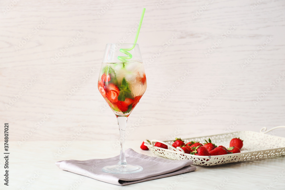 Glass of tasty strawberry mojito on table