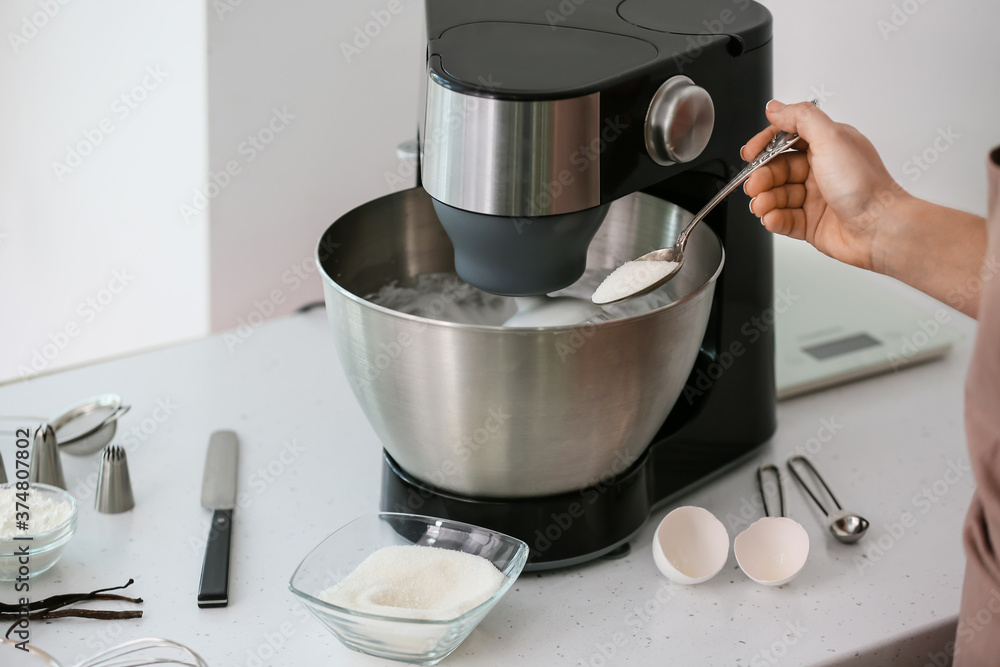 Woman preparing meringue in kitchen