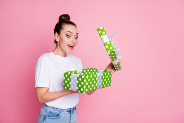 Wall Mural - Turned photo of astonished positive girl open dream package big green dotted gift box impressed wear casual style clothes isolated over pink color background