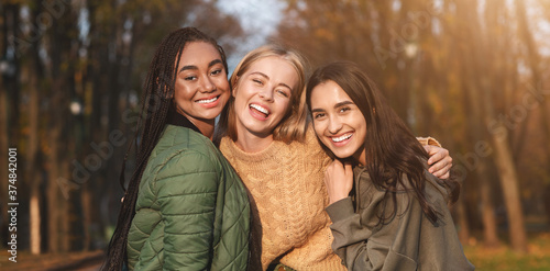 Cuadros en Lienzo Portrait of three young girlfriends spending time in park
