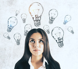 Canvas Print - Businesswoman looking on drawing light bulbs over head.