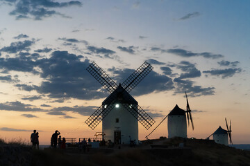 Canvas Print - Amazing shot of windmills on an orange sunset background