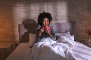 Wall Mural - Woman drinking morning coffee in bed