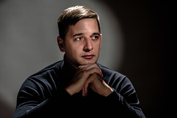 Wall Mural - Handsome young man in black sweater posing on vintage background