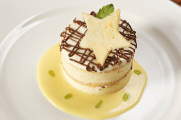 Vanilla dessert with custard, chocolate and star-shaped biscuit.