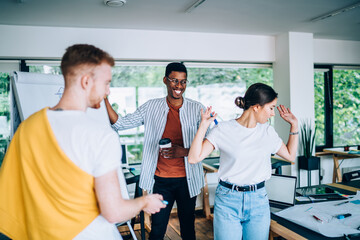 Wall Mural - Black playful male discussing project with coworkers