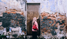 Rear View Of Woman Standing Against Wall