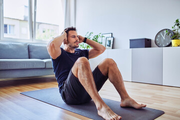 Sporty man doing sit-ups exercise during home workout