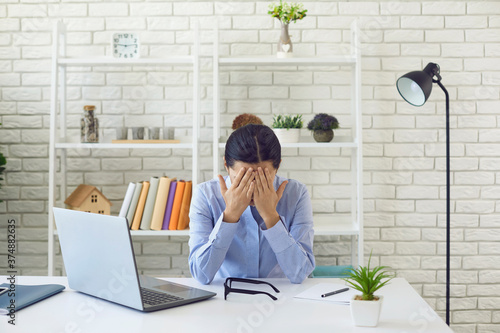 Fotografía Exhausted young woman working overtime at office