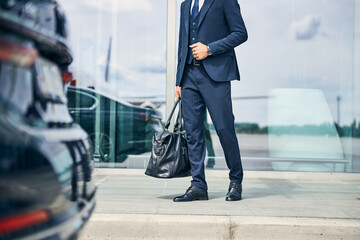 Elegantly dressed man walking towards an automobile