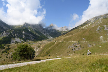 Wall Mural - landscape of the mountain peaks of the Alps, rugged and rocky mountains, part of the French Alps mountain range. The sky between clear blue, is covered with white clouds, you can see in the valley the