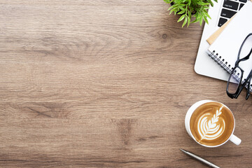 Wall Mural - Wood office desk table with laptop computer, cup of latte coffee and office supplies. Top view with copy space, flat lay.